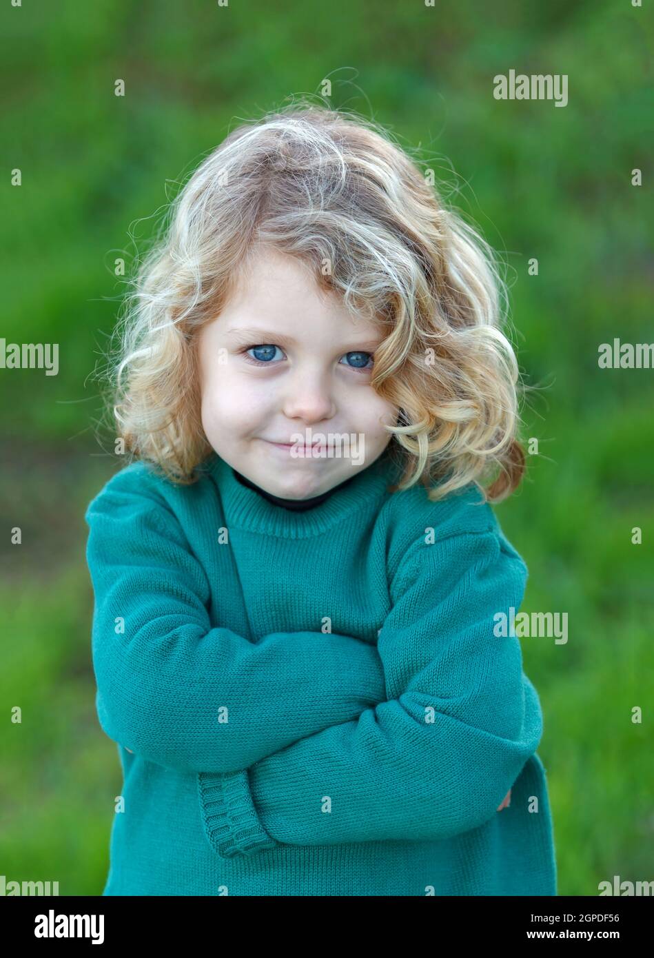 Small angry kid with green jersey in the field Stock Photo