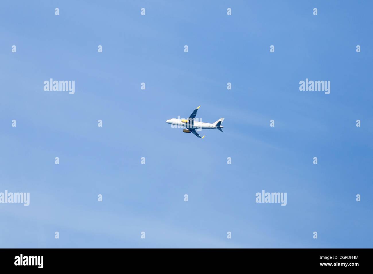 white airplane flying in a clear pale blue sky Stock Photo - Alamy