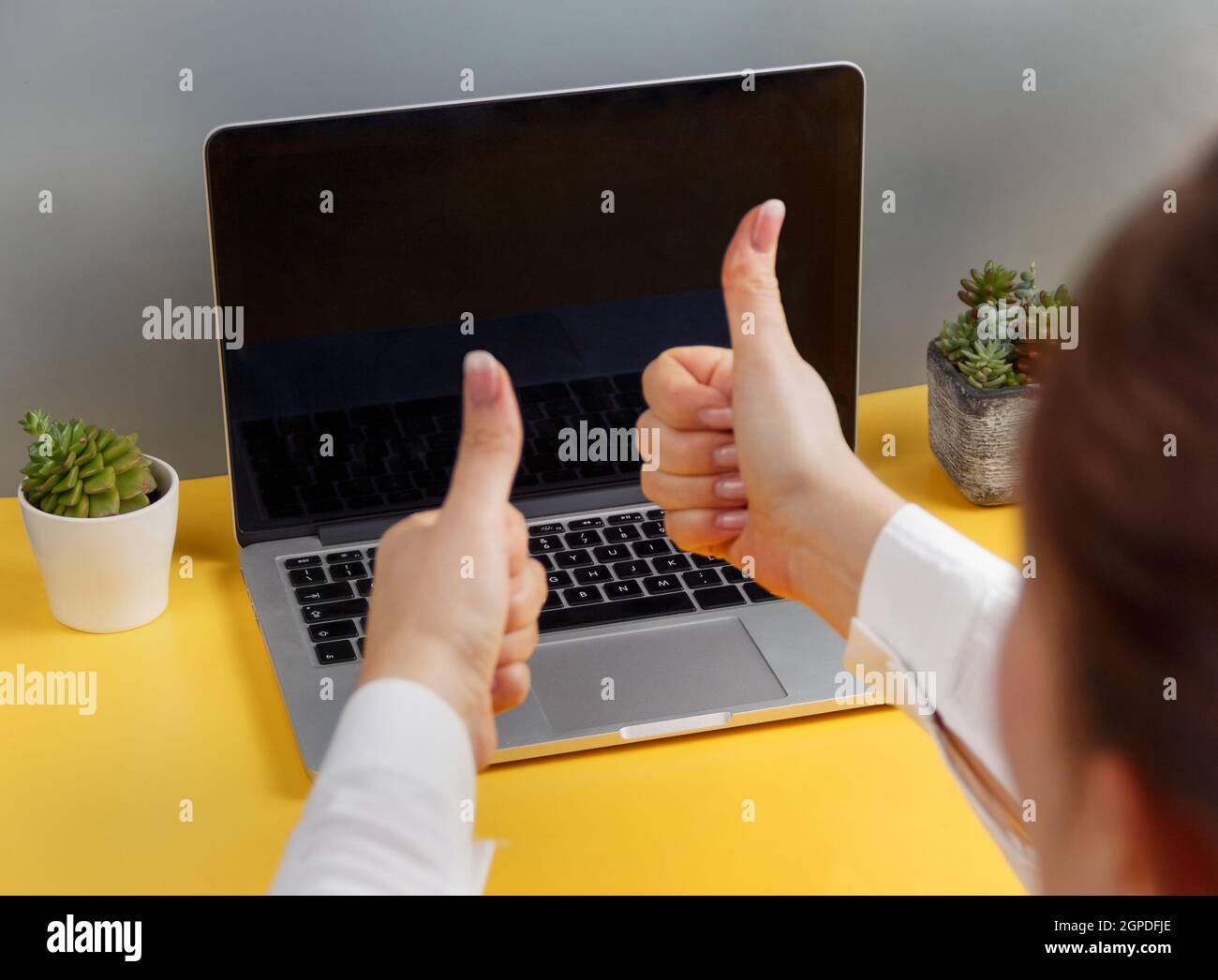 Woman showing thumbs up during a video call on laptop close up Stock ...