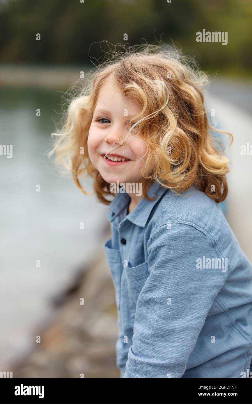 Happy small child with long blond hair enjoying the holidays Stock Photo
