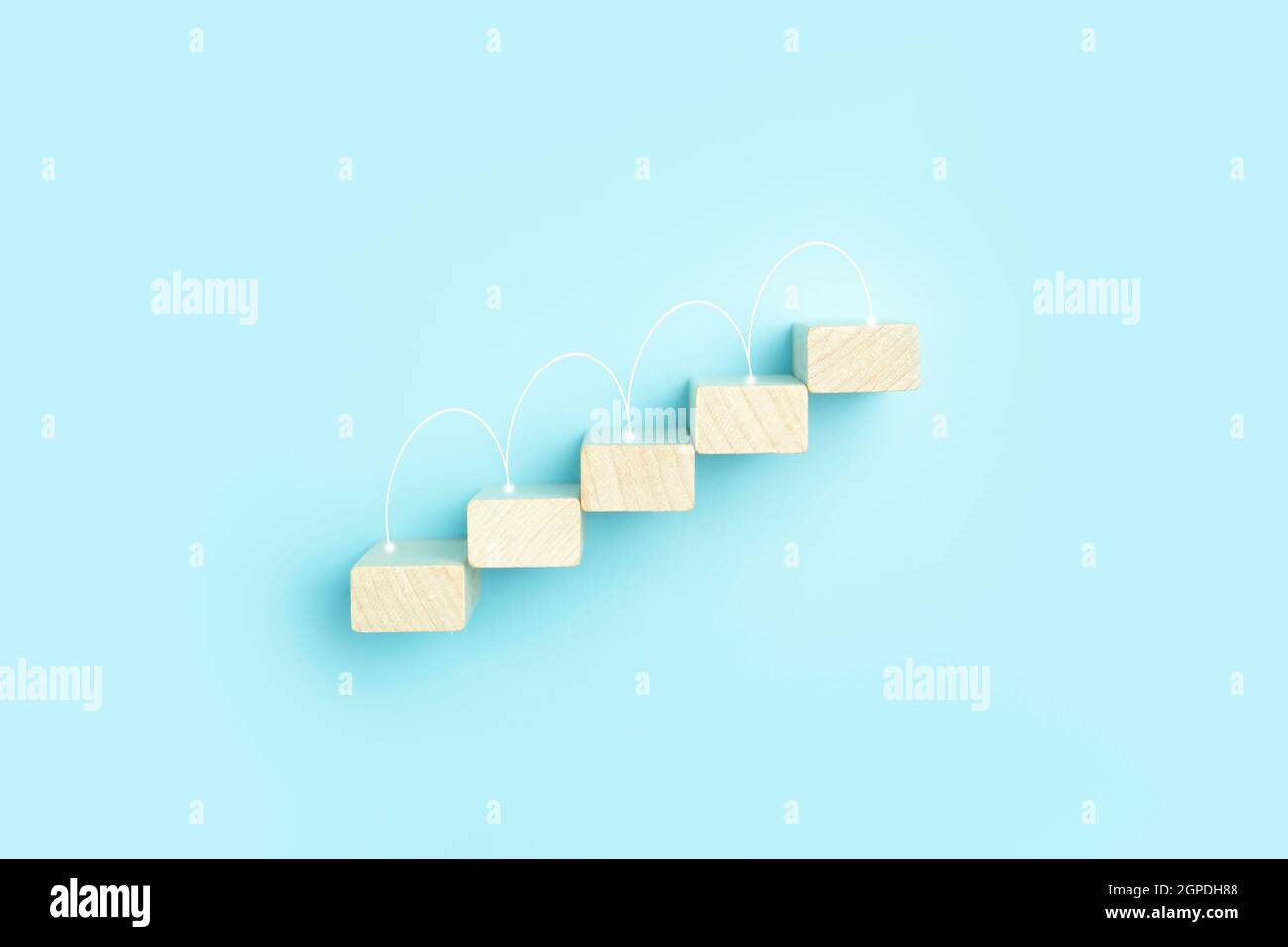 Business growth, development plan concept and business analytics background. Wooden steps of blocks on a blue background as financial and career growth, increase in monetary income and economic development. High quality photo Stock Photo