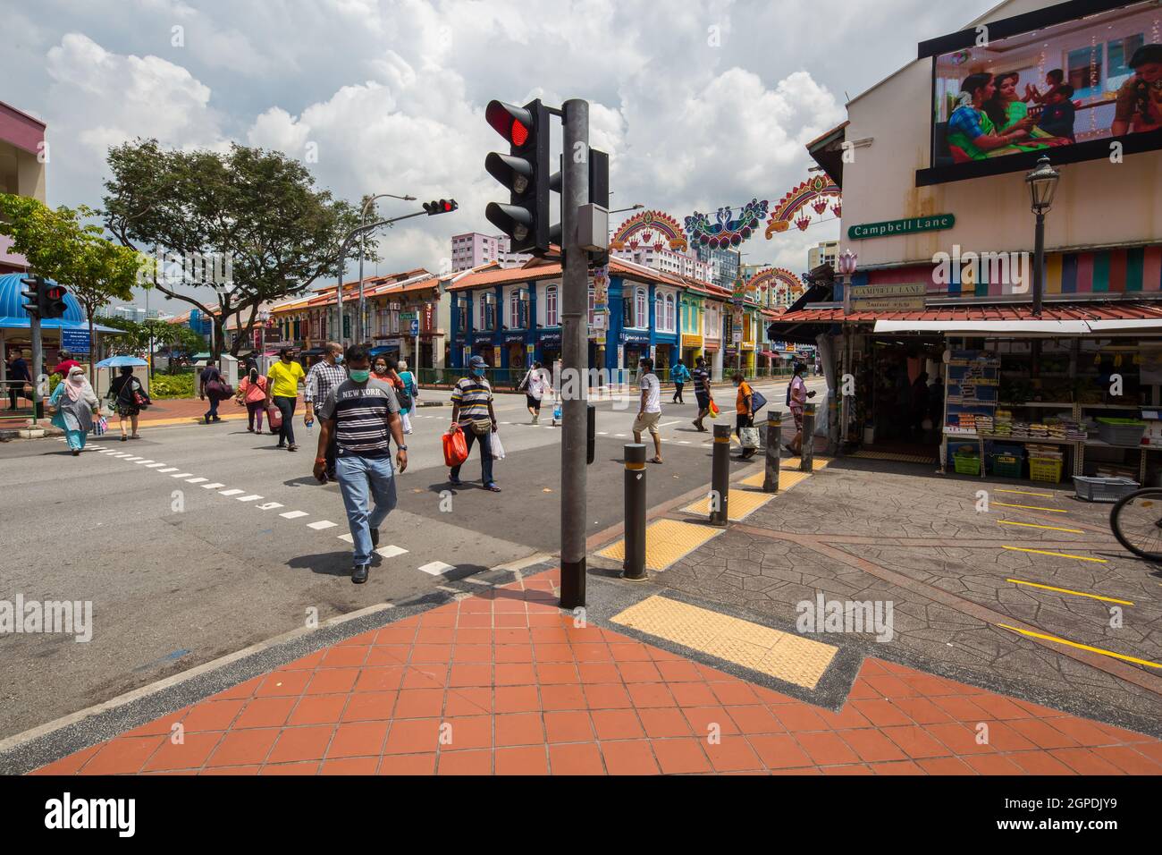 People wearing mask are crossing the road, public are encourage to wear a mask at outdoor condition to prevent virus spread. Little India, Singapore. Stock Photo