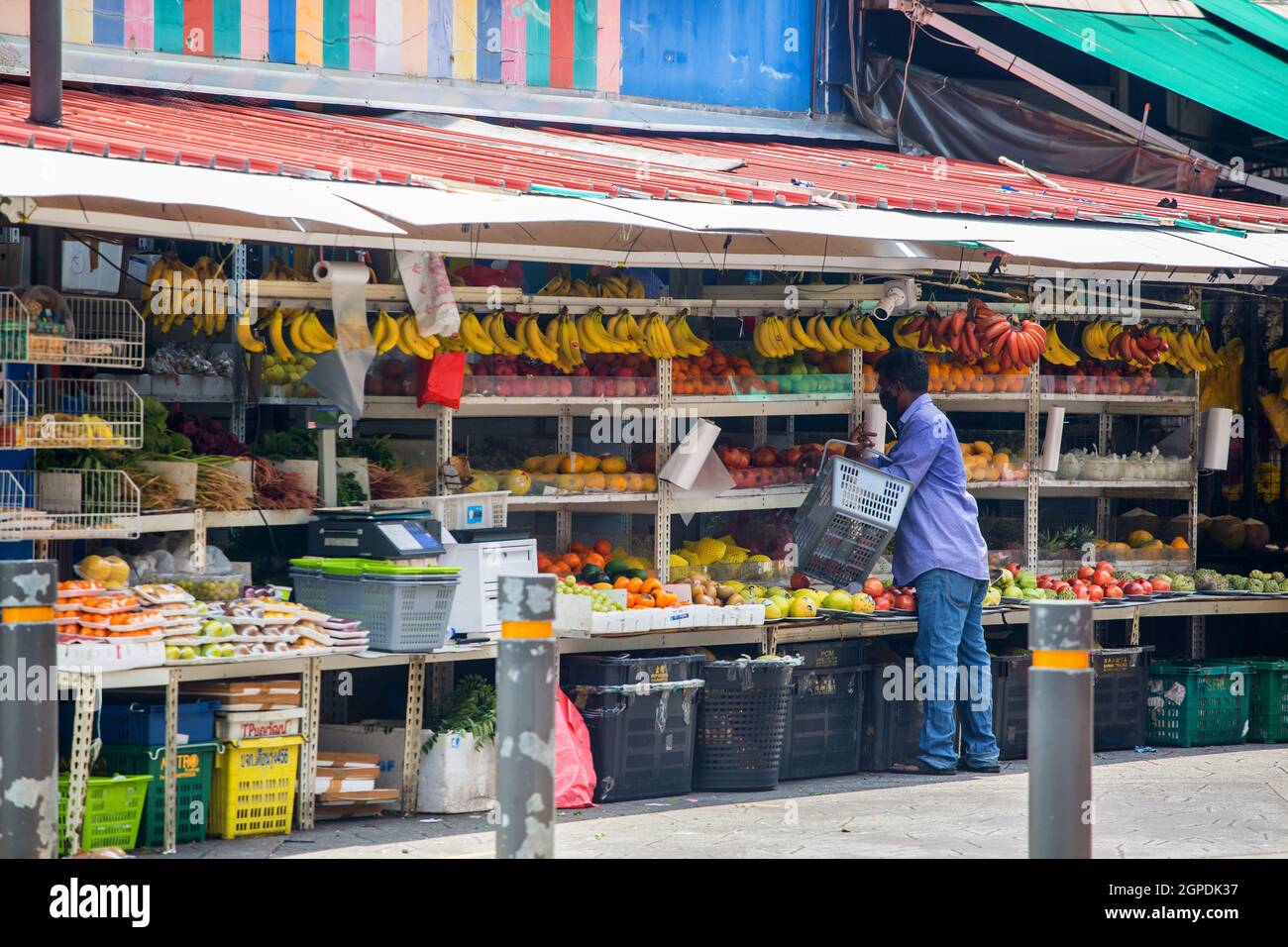 An Indian man holding a basket shopping at outdoor fruits store, Little India, Singapore. Stock Photo