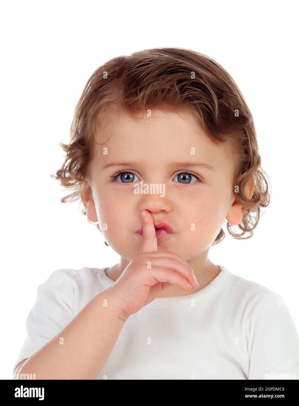Cute baby has put forefinger to lips as sign of silence, isolated on a