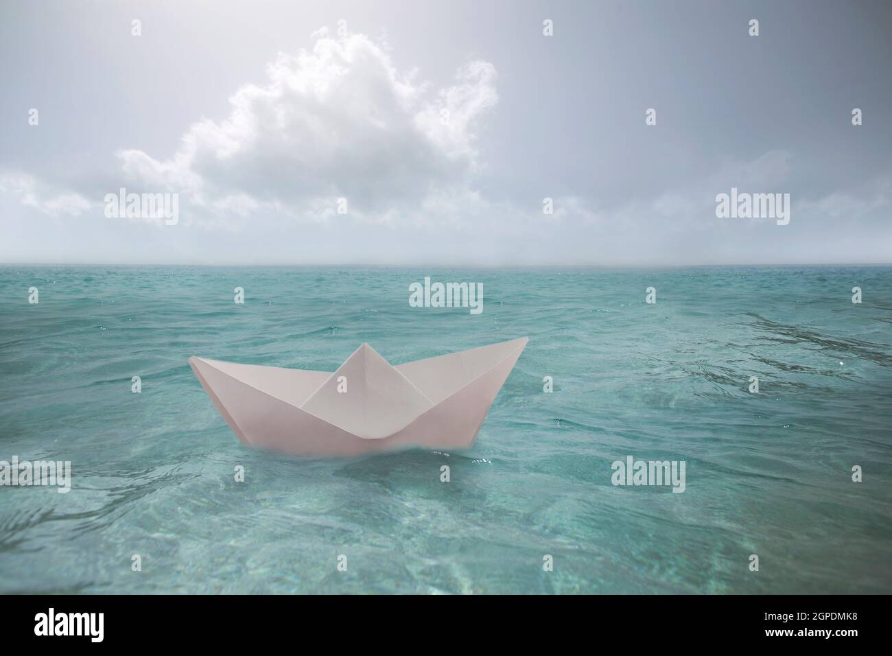 surreal paper boat travels alone in the infinite ocean Stock Photo