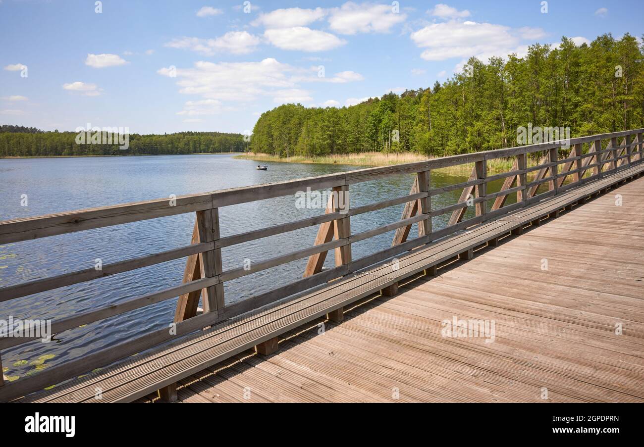 Wooden bridge over Osiek lake, Poland. Stock Photo