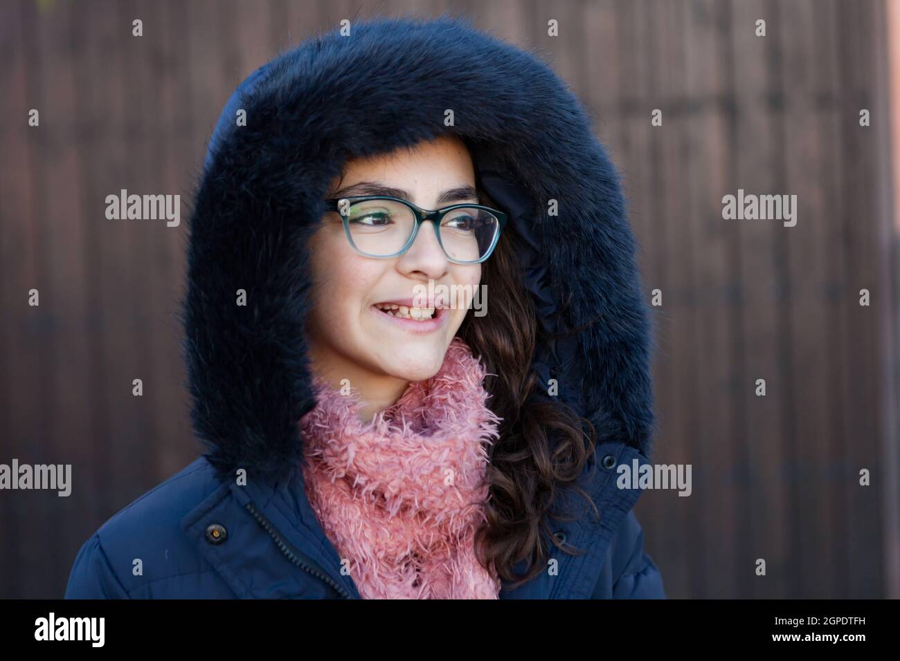 Smiling preteen girl wearing fur hood at winter Stock Photo