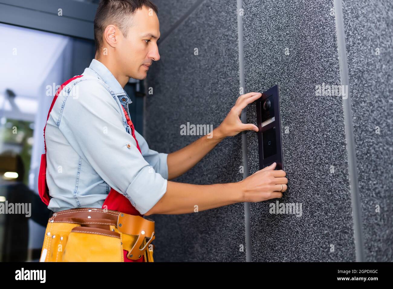 Builder installing an intercom. renovation in a renovated building Stock Photo