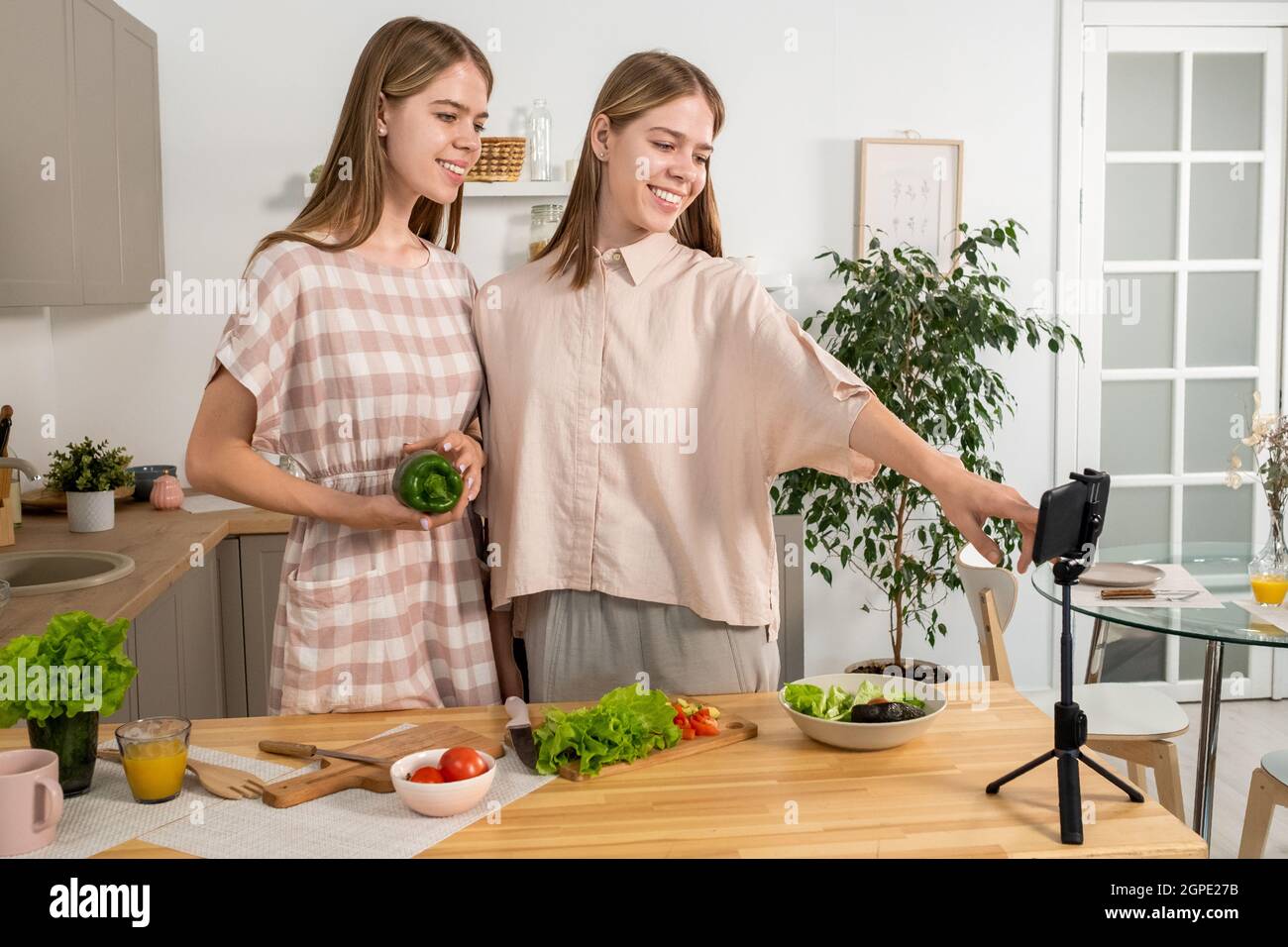 Cute smiling twins making livestream of cooking masterclass in the