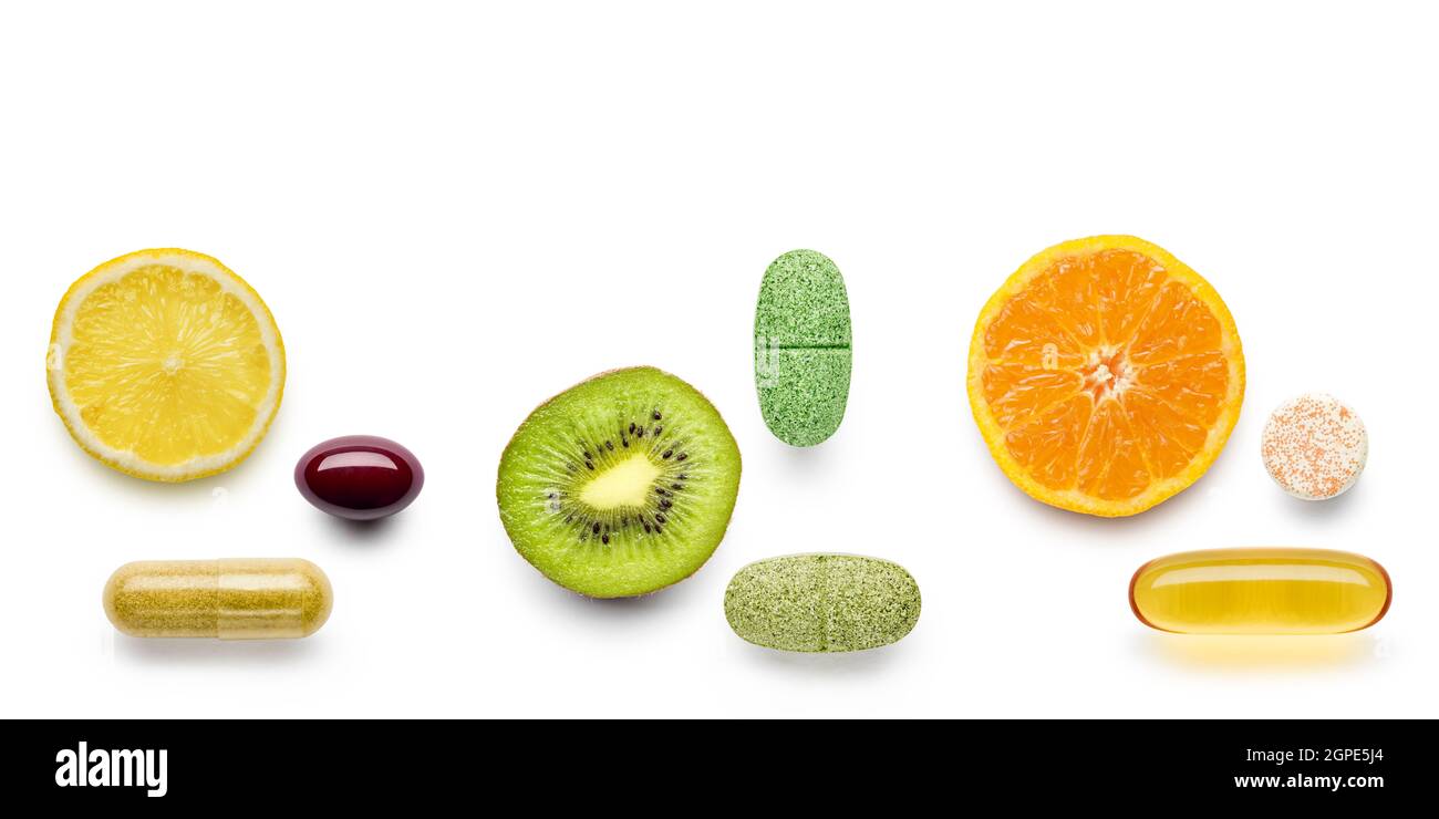 various vitamin supplement pills with citrus fruits on white background Stock Photo