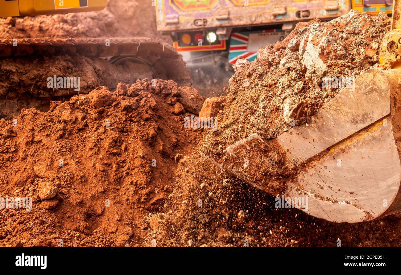 Backhoe working by digging soil at construction site. Bucket of backhoe