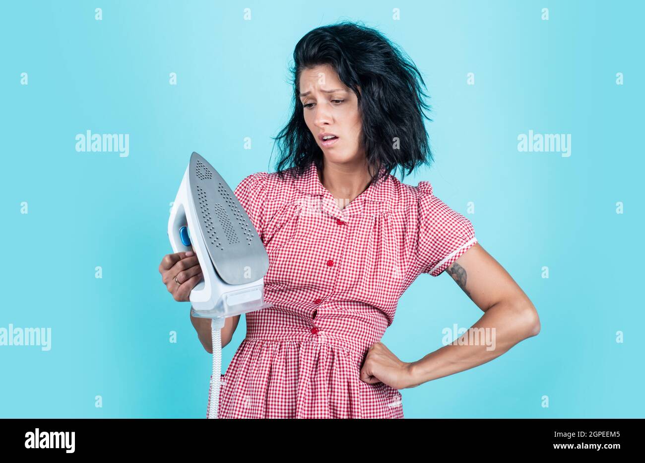 cant live without it. unhappy housekeeper ironing. concept of householding. steaming iron. pinup girl prepare ironing. lady hold modern iron. Everyday Stock Photo