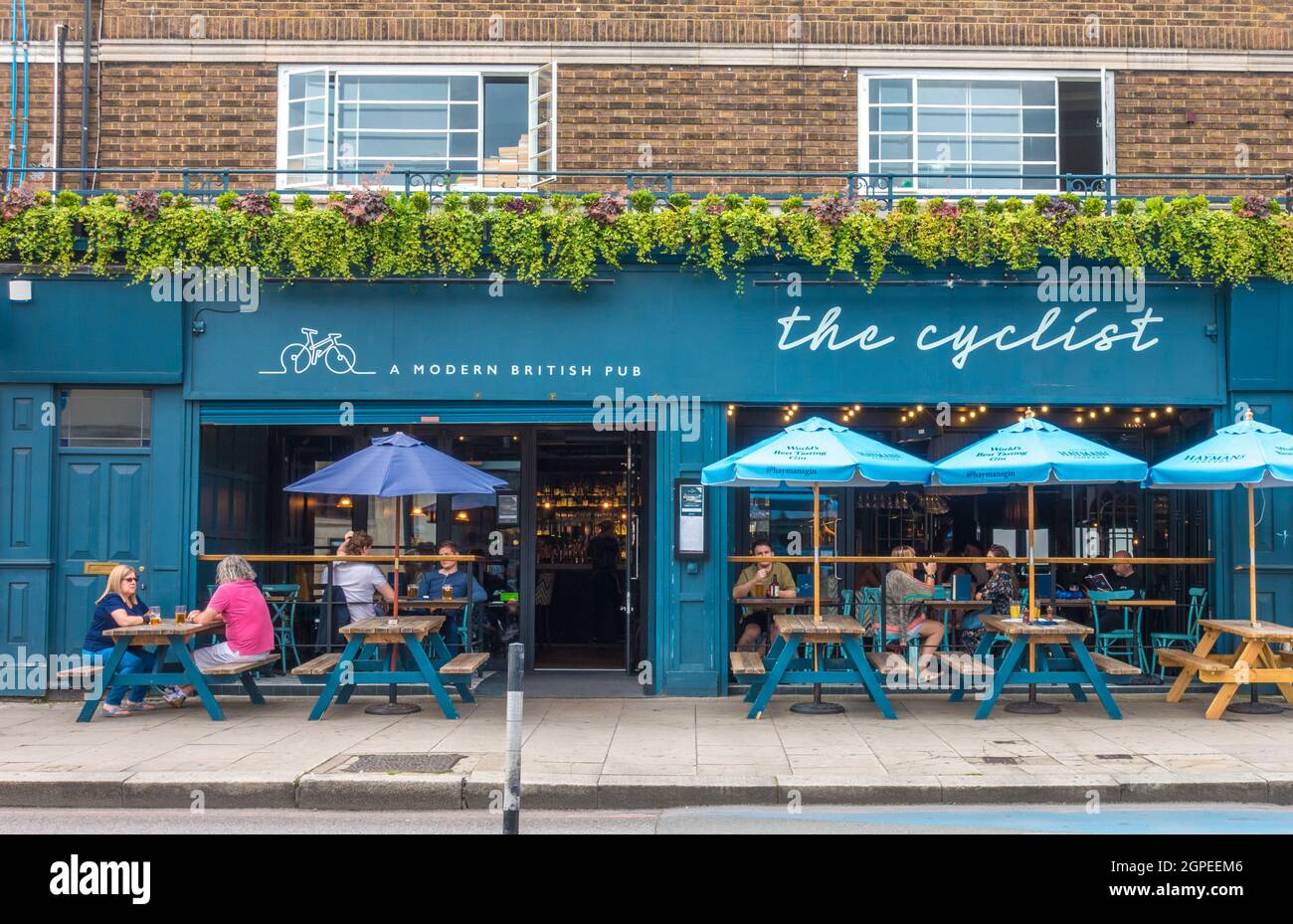 The Cyclist – a modern British pub - with people sitting at tables inside and outside, in Balham, London, SW12, England, UK. Stock Photo