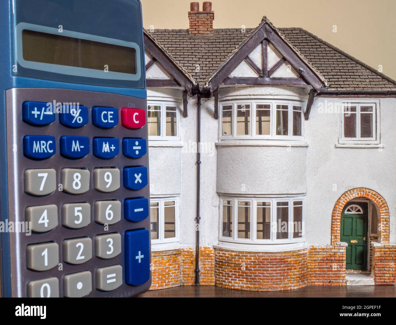 Housing / property market concept: A calculator next to a model / toy pair of semi-detached houses. Stock Photo