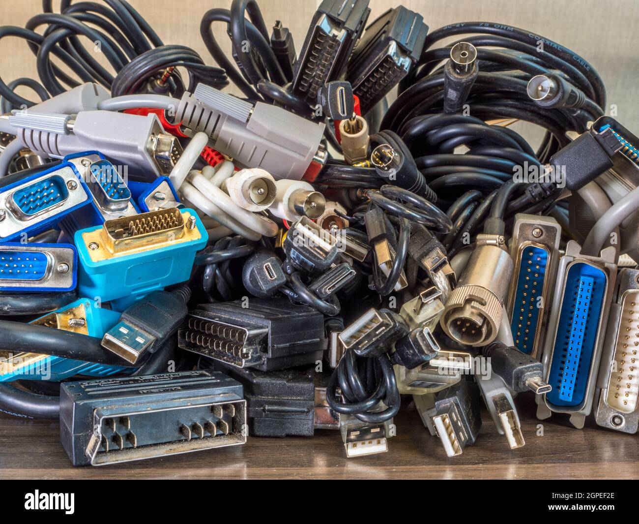 Closeup POV shot of a pile of old computer, audio, video and television cables / cords, with an assortment of plugs / sockets / connectors. Stock Photo