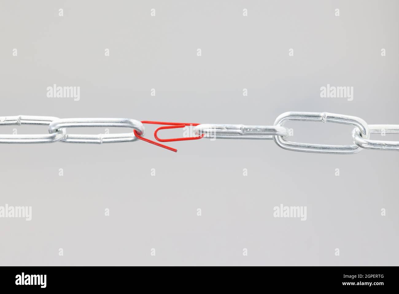 Chrome chain in middle with red paper clip Stock Photo
