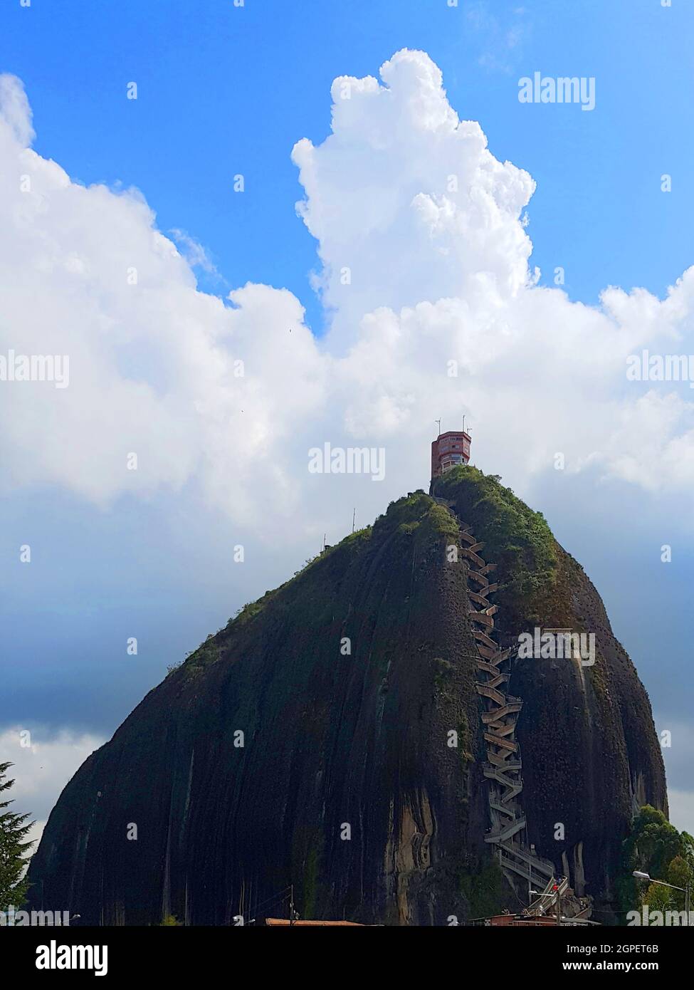 Vertical shot of El Penon de Guatape under a blue cloudy sky in Colombia Stock Photo