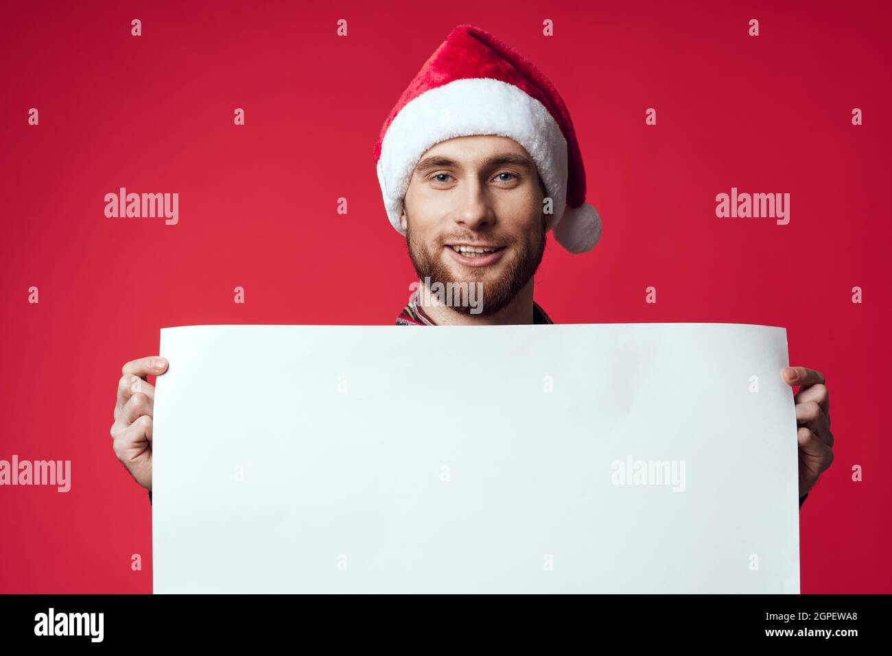 Cheerful man in a santa hat holding a banner holiday isolated ...
