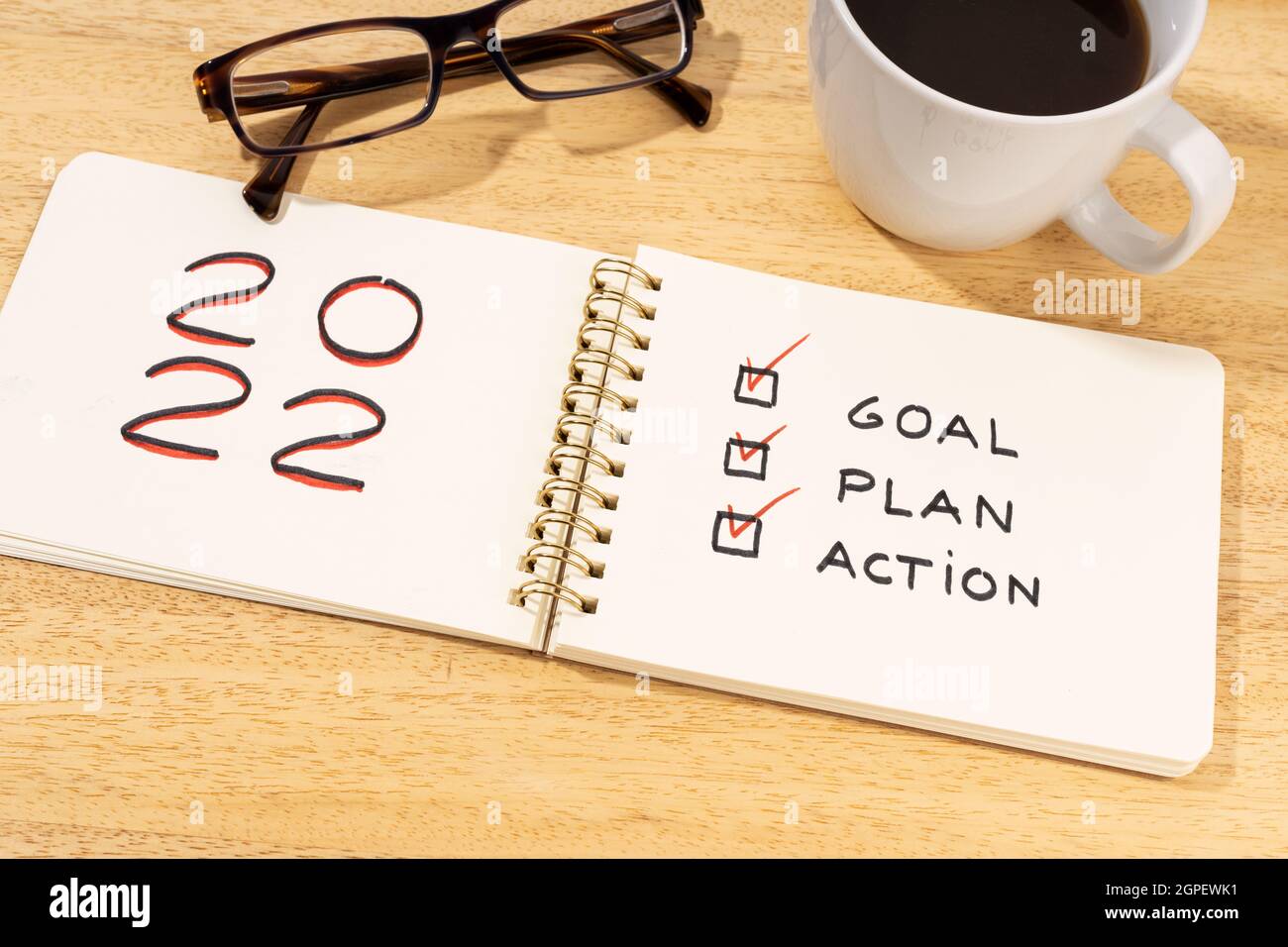 New year 2022 goal, plan, action text on notepad on wooden desk. Motivational checklist concept Stock Photo