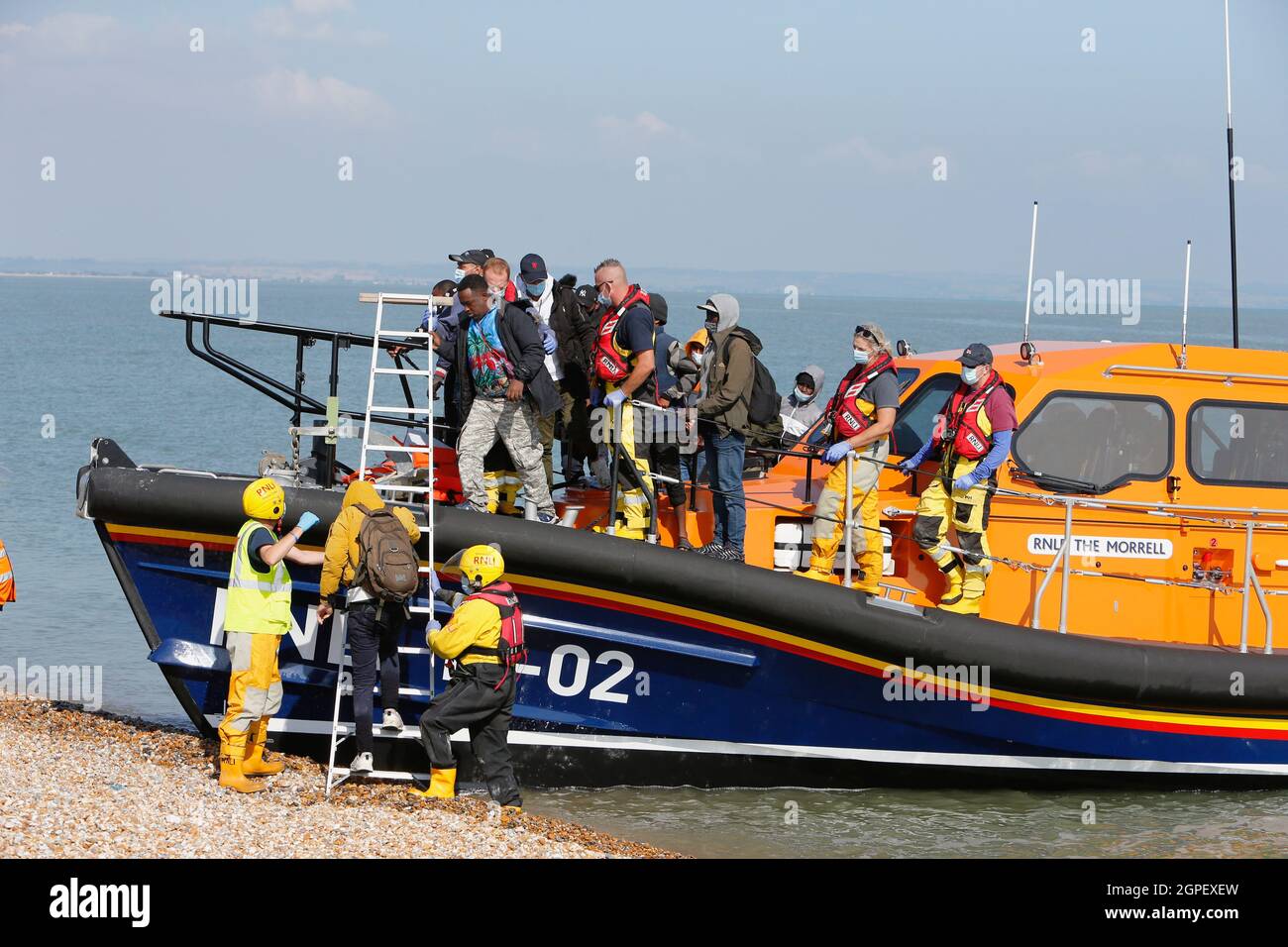 England, Kent, Dungeness, RNLI, helping migrants who have crossed the channel onto the beach. Stock Photo