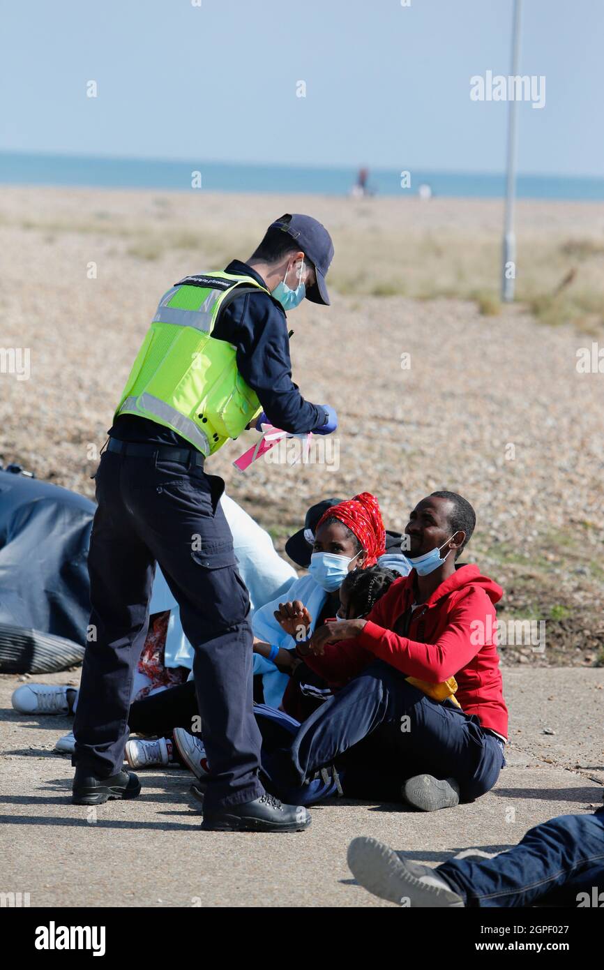 England, Kent, Dungeness, Migrants being searched by immiragtion officers on the beach. Stock Photo