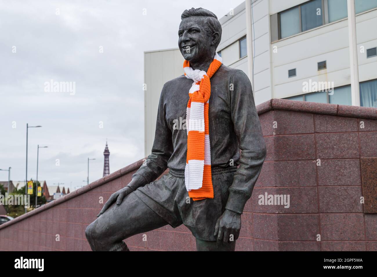 A statue of former Blackpool FC player and manager Jimmy Armfield seen outside Bloomfield Road stadium in September 2021 with the Blackpool Tower in t Stock Photo