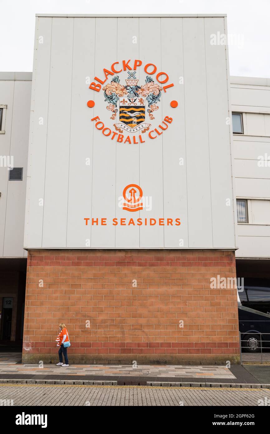 A senior woman dressed in an orange replica shirt and scarf walks to Bloomfield Road to watch Blackpool FC take on Barnsley FC in September 2021. Stock Photo