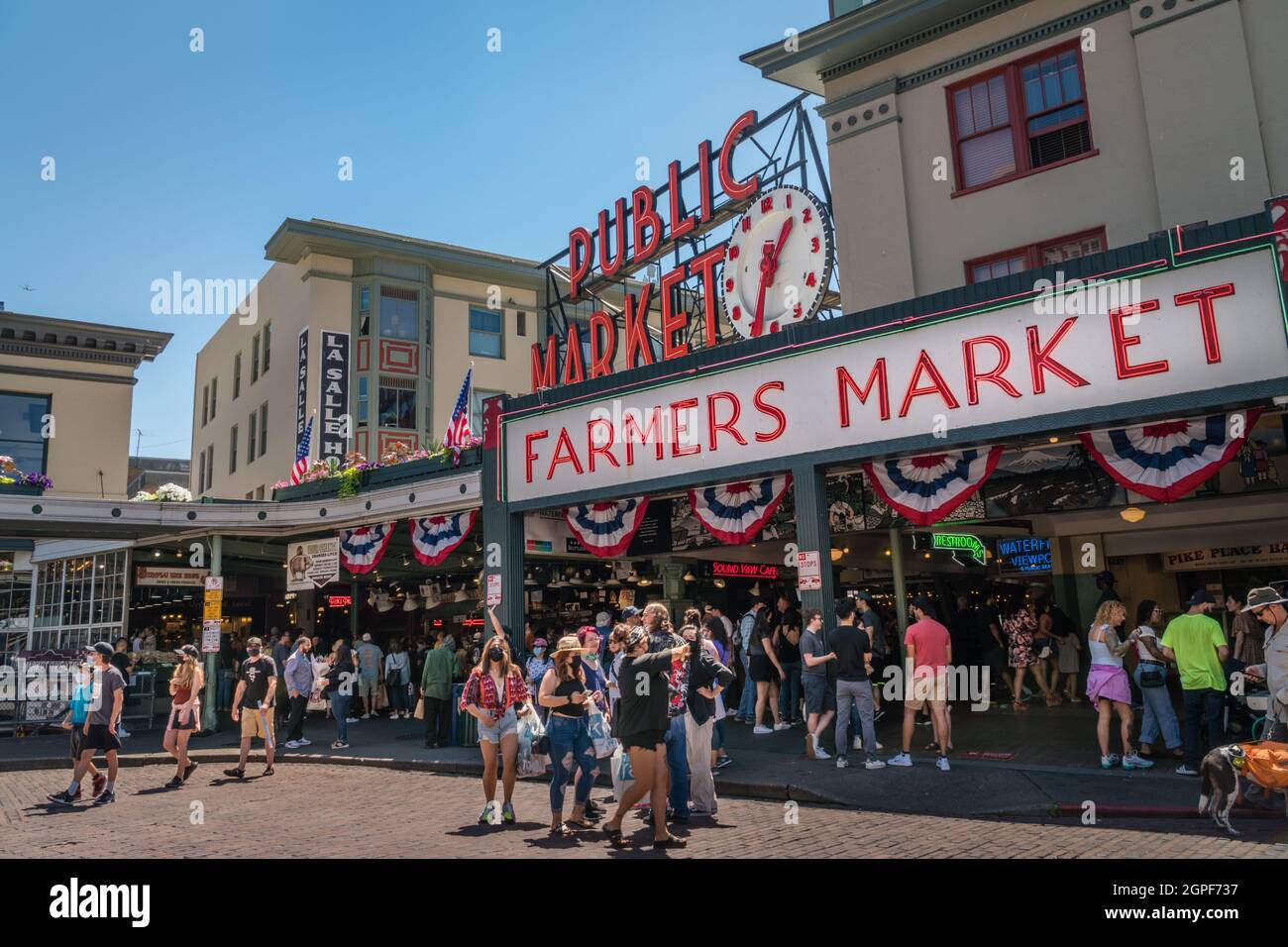 Seattle, WA, US - July 3, 2021: Seattle Public Farmers Market is busy on a summer day during the covid pandemic. Some people wear masks. Stock Photo
