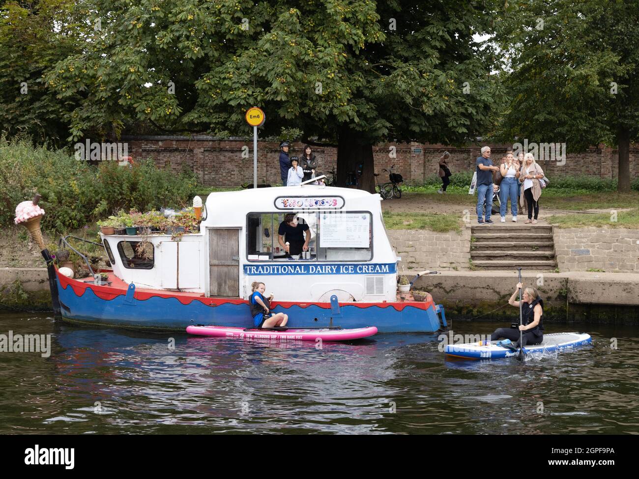 People buying ice cream in their canoes from an ice cream boat on the River Ouse, York UK Stock Photo