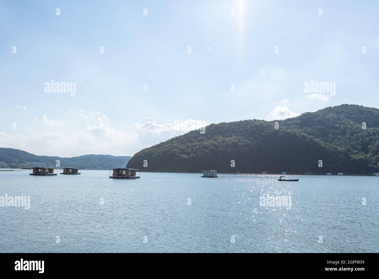 fishing seats on the water with passing boat, Idong reservoir, Yongin-si, Korea Stock Photo
