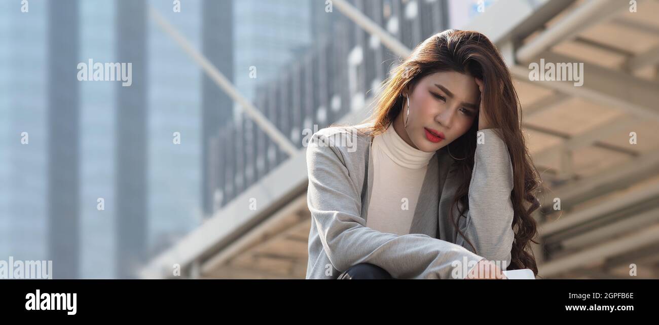 Lay off. Sacked. Fired business woman sitting on stairs of office building outside. Depressed
