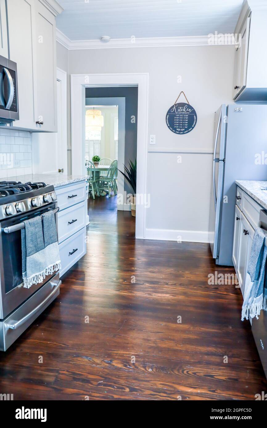 A small cottage kitchen with gray and dark hardwood floors in
