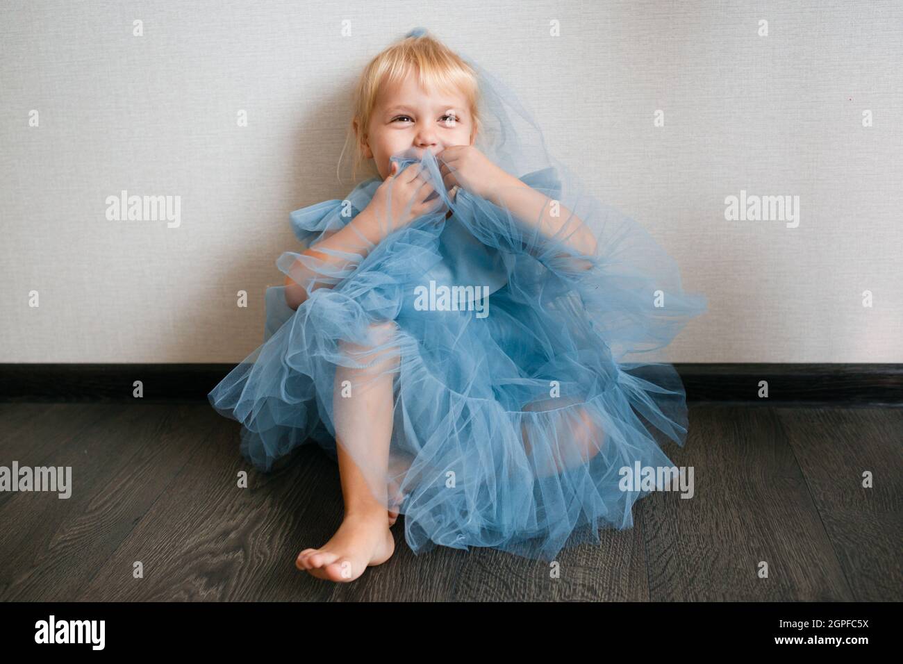 Little white girl in a blue dress laughs. Preschooler Stock Photo - Alamy