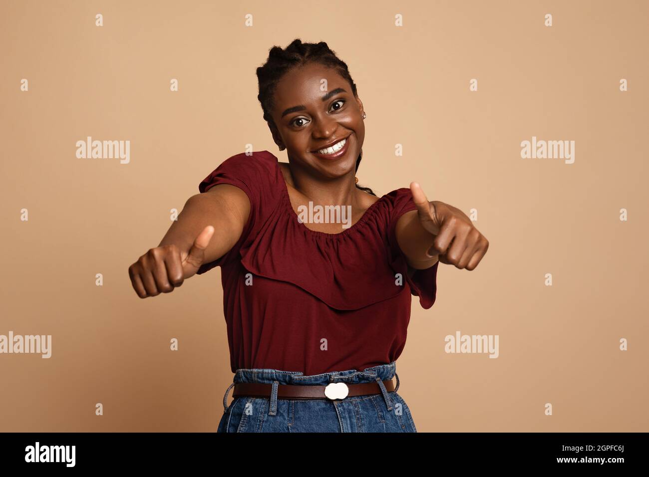 Positive african american young woman showing thumb ups Stock Photo - Alamy