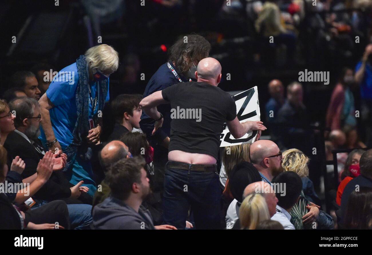 Brighton UK 29th September 2021 - A delegate holds up a No Purge poster but is forced by other delegates to sit down during Keir Starmer's speech to the Labour Party Conference today at the Brighton Centre  : Credit Simon Dack / Alamy Live News Stock Photo