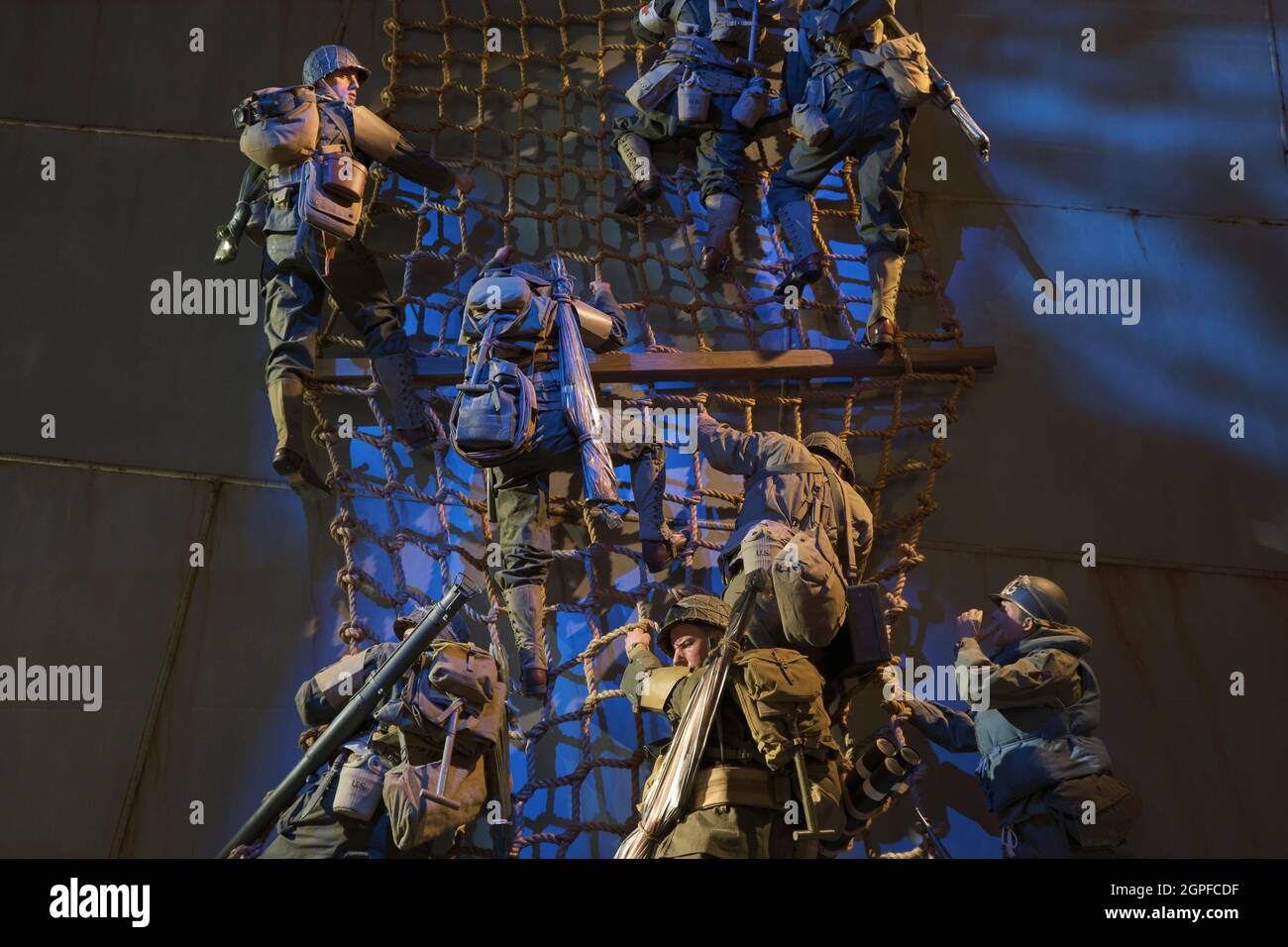 Soldiers climbing down a rope ladder onto a Higgins landing craft transport boat during D-Day in WWII. At the National Museum of the United States Arm Stock Photo