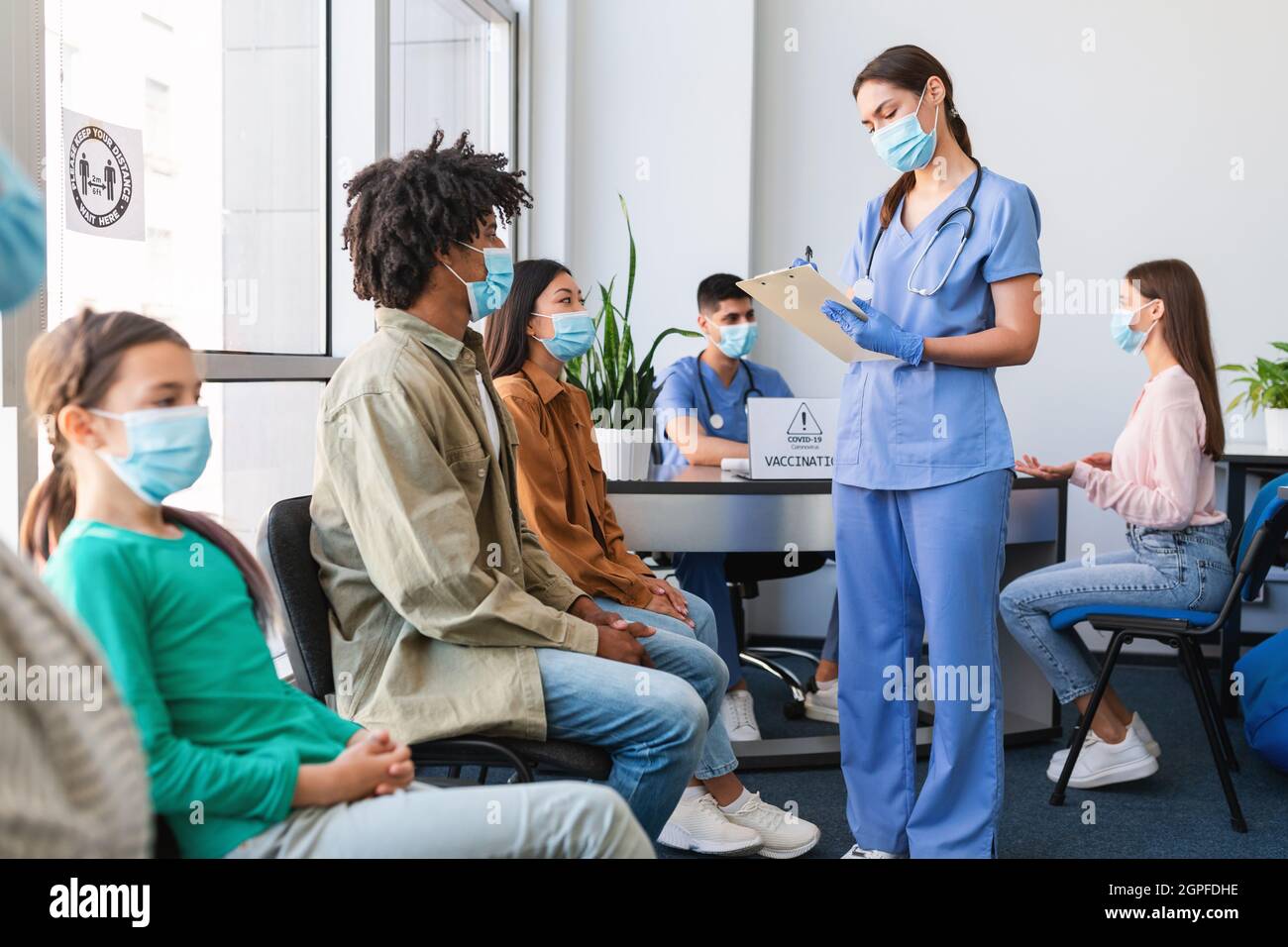 Diverse Patients Waiting For Covid-19 Vaccination Sitting In Queue Stock Photo