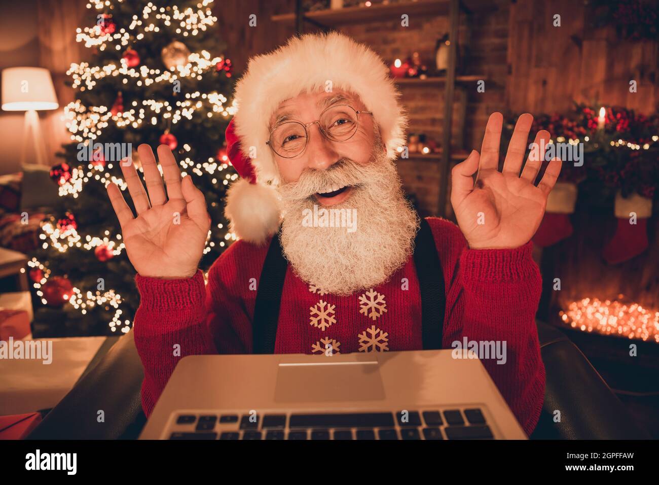 Portrait of attractive cheerful Santa December day waving hello using ...
