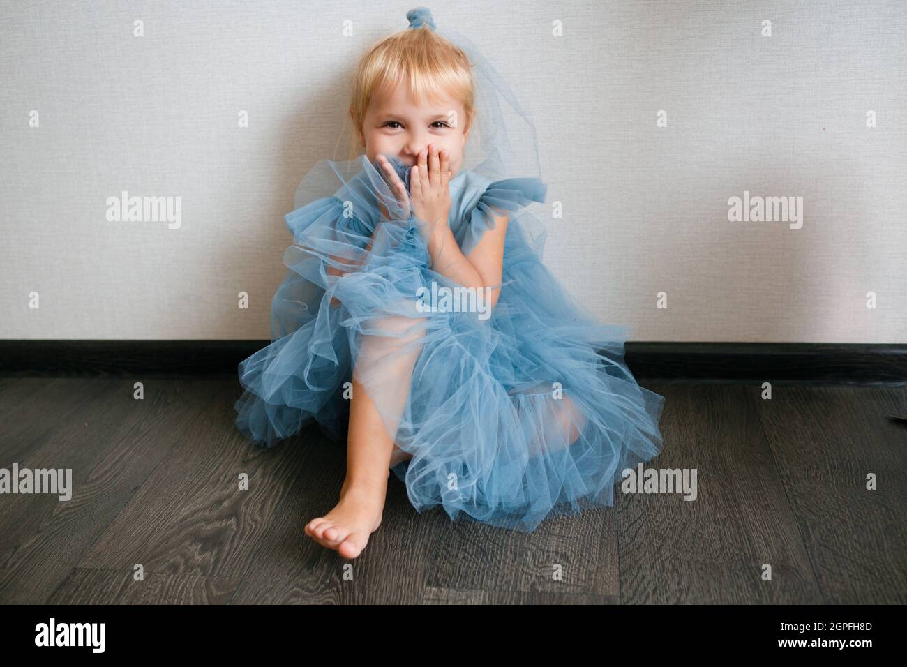 Little white girl in a blue dress laughs. Preschooler Stock Photo - Alamy