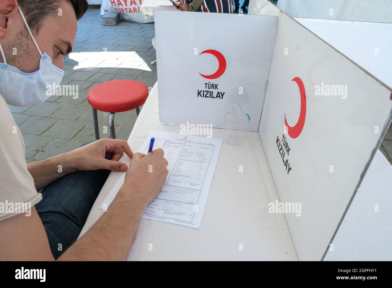 Eminonu, Istanbul, Turkey - 07.05.2021: close up detail of a blood donation male volunteer signing official approval document on a table under a tent Stock Photo