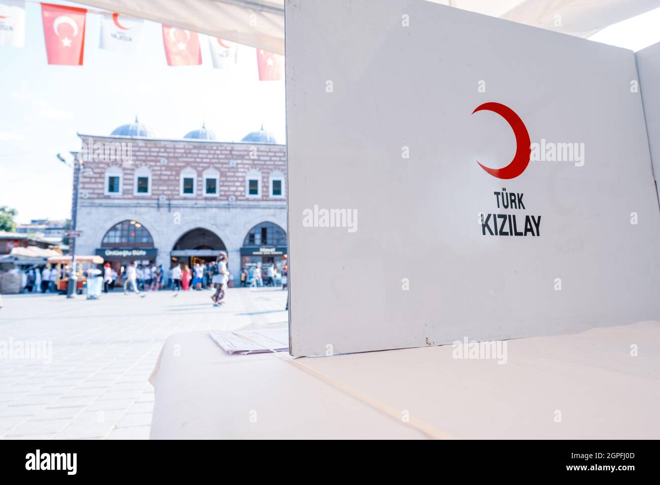 Eminonu, Istanbul, Turkey - 07.05.2021: logo of Turkish Red Crescent (Türk Kizilay) on white table where volunteers sign approval documents in a crowd Stock Photo