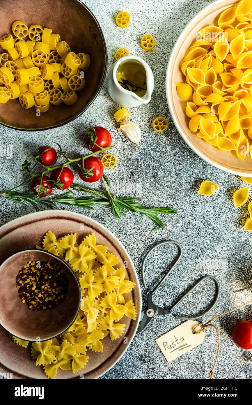Italian pasta cooking concept with variety of pasta, spices and vegetables Stock Photo