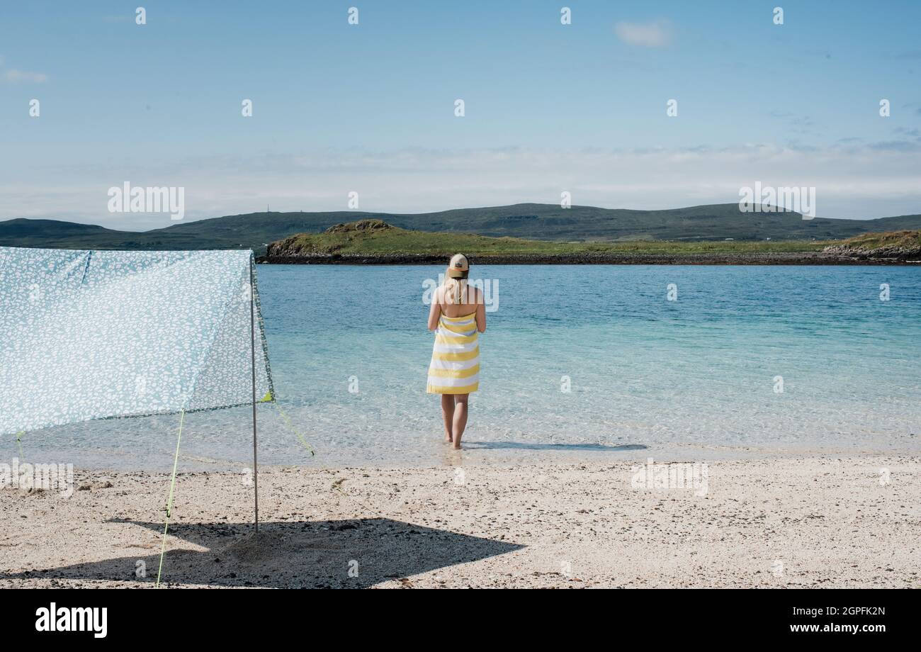 woman stood at the beach looking at the water on a beautiful day Stock ...