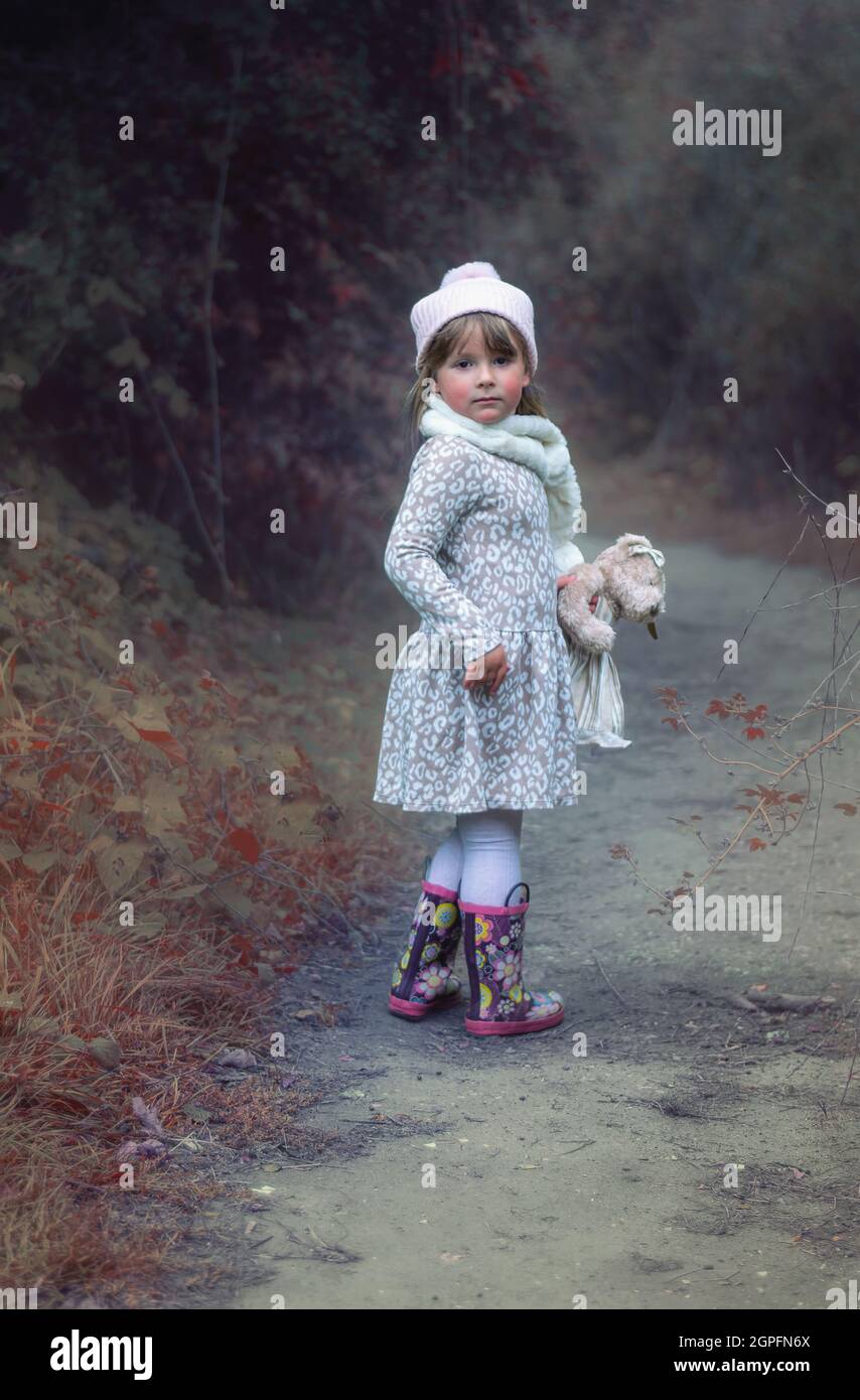 Cute little girl with a teddy bear in the forest Stock Photo - Alamy