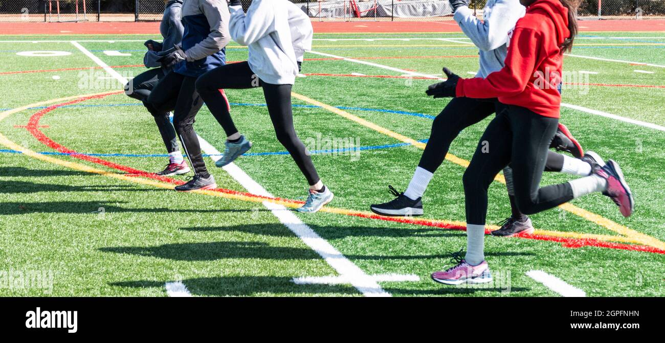Side view of a high school girls track team performing running speed