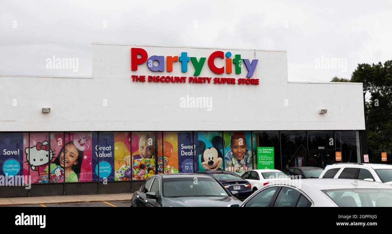 North Babylon, New York, USA - 18 August 2021: The entrance of a Party City Discount party super store from the parking lot with cars. Stock Photo