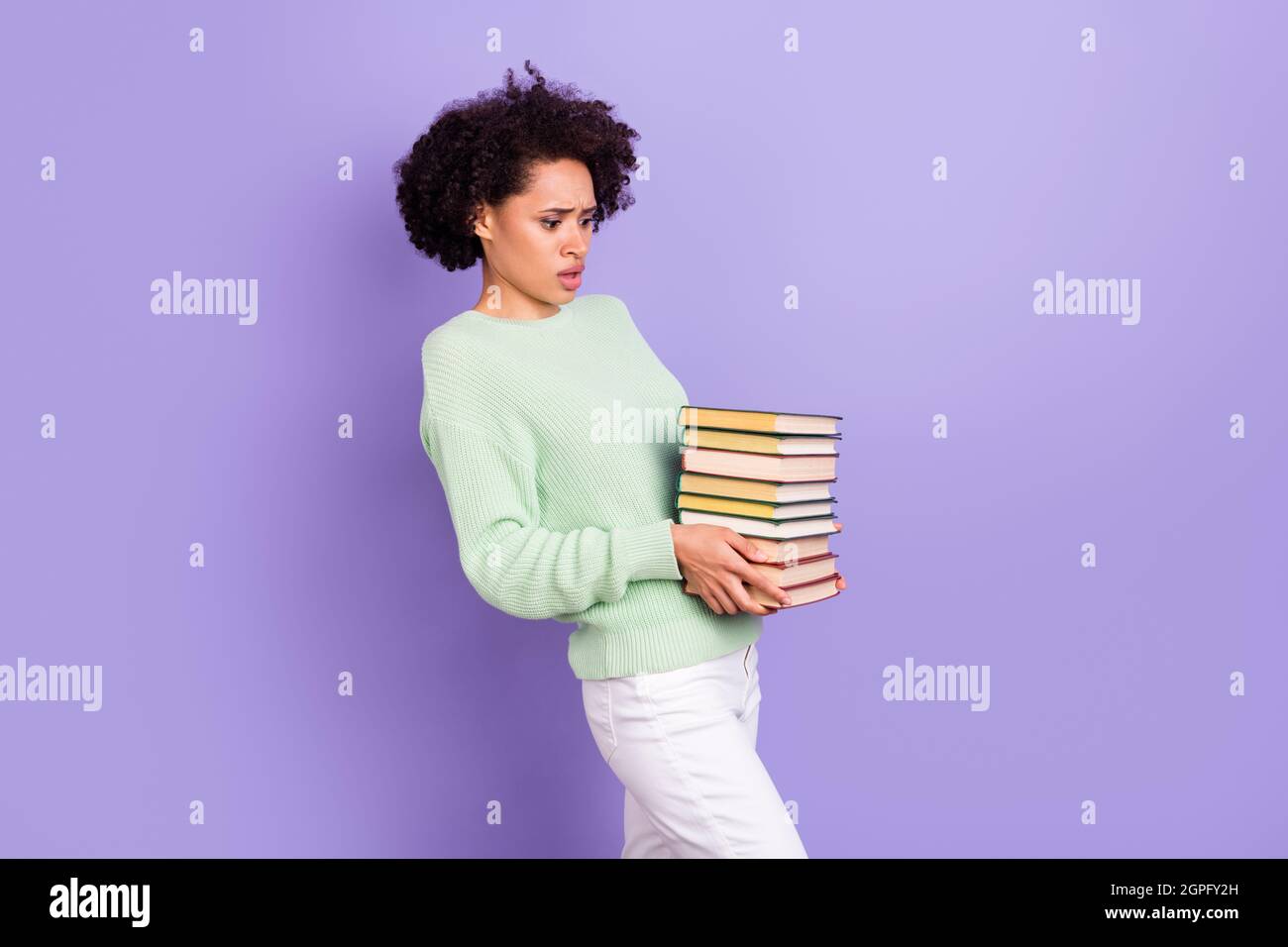 Photo of young unhappy upset dark skin sad woman hold hands books bad mood heavy isolated on purple color background Stock Photo