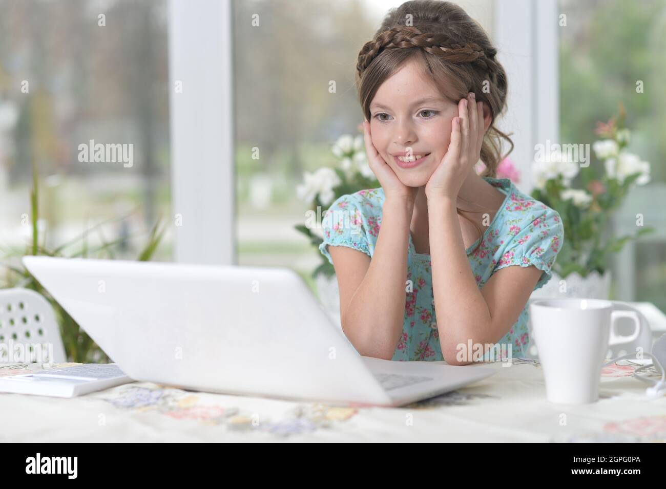 Cute little girl using laptop at home Stock Photo - Alamy