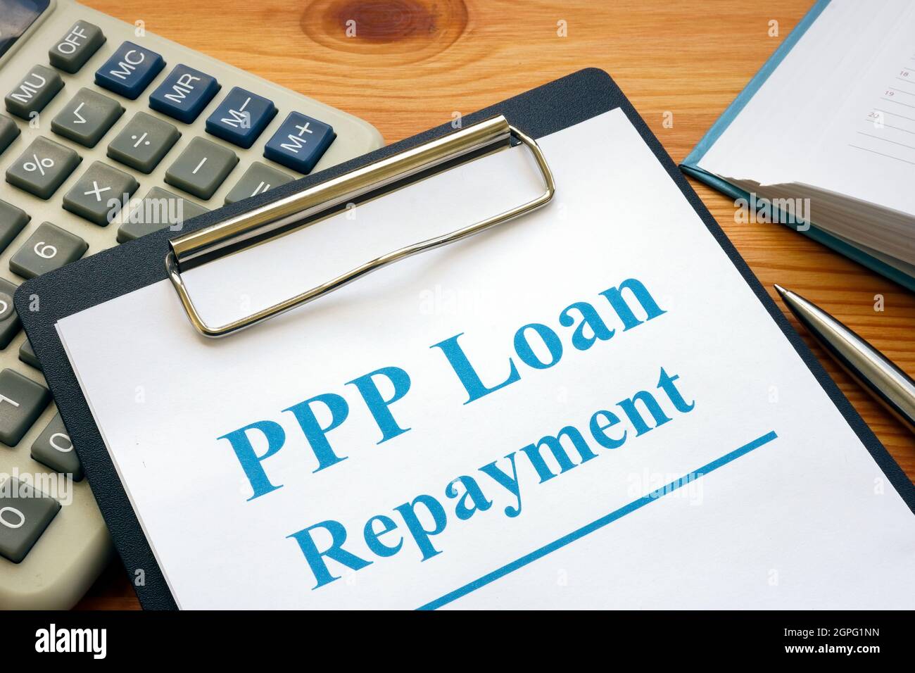 PPP loan repayment form and clipboard with calculator. Stock Photo