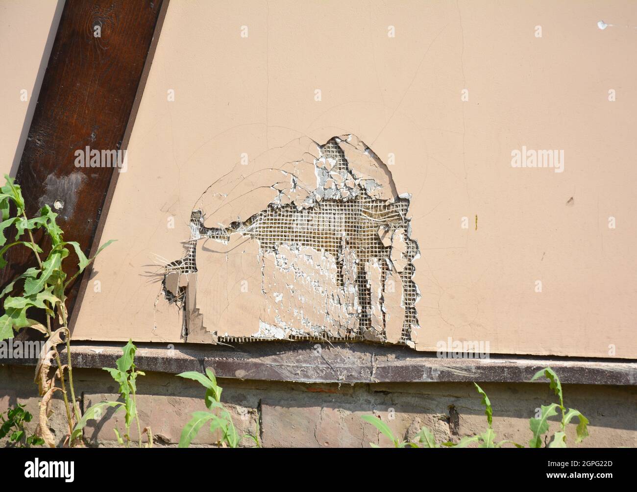 Repair cracks and holes in house wall stucco. Repairing a hole in a